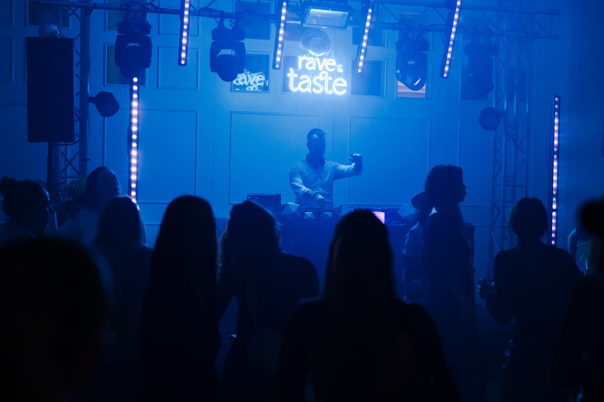 Rave & Taste Bühne mit blauem Licht und tanzenden Gästen